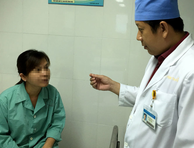 Bác sĩ đang thăm khám cho một phụ nữ tại BV Tai mũi họng 